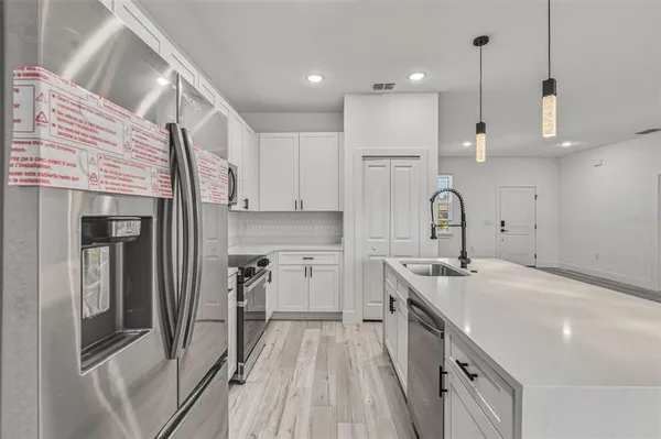 a kitchen with a sink a stove and cabinets