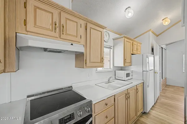 a kitchen with stainless steel appliances granite countertop a sink and a refrigerator