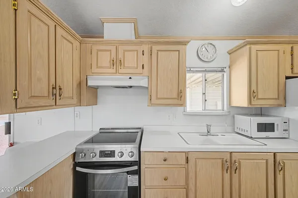 a kitchen with stainless steel appliances granite countertop a stove a sink and a white cabinets