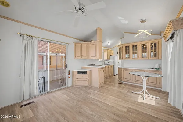 a kitchen with kitchen island a stove a refrigerator and a dining table with wooden floor