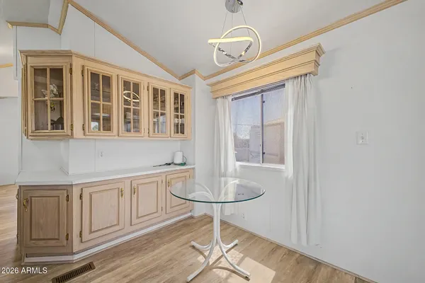 a room with chandelier fan and wooden floor
