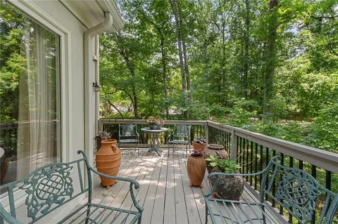 a view of a balcony with chairs and wooden floor