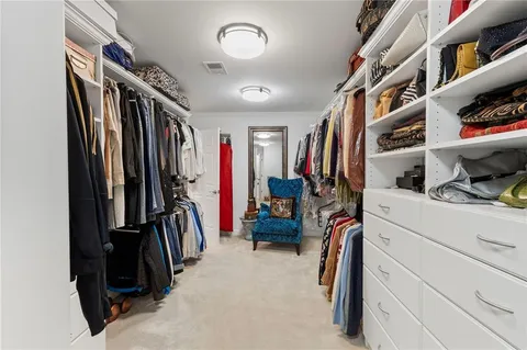 a view of walk in closet with clothes and shoes