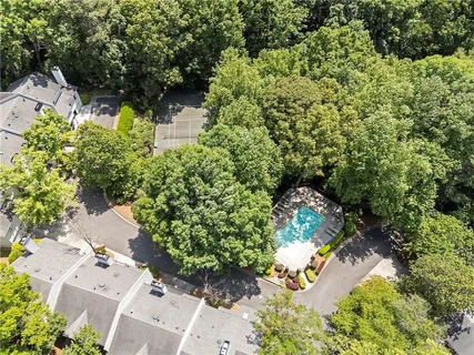 an aerial view of residential house with outdoor space and trees all around
