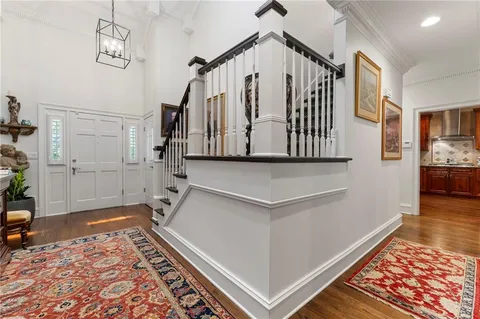 a view of a hallway with wooden floor and staircase