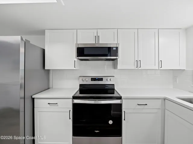 a kitchen with stainless steel appliances a stove microwave and sink