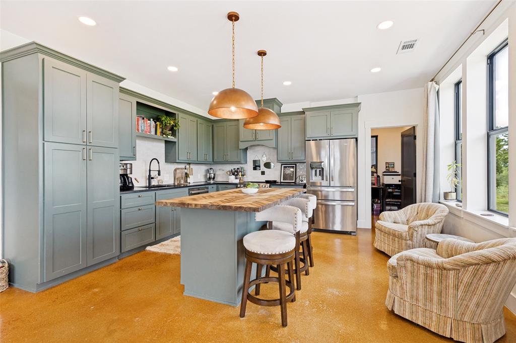 490 Private Road 4512 Decatur, TX 76234 - Photo 9 of 27 Spacious kitchen featuring custom cabinetry, a large kitchen island with a wood-finish countertop, stainless steel appliances, and polished concrete flooring