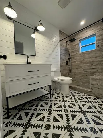 a bathroom with a sink a toilet and a mirror