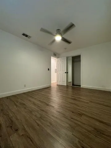a view of an empty room with wooden floor