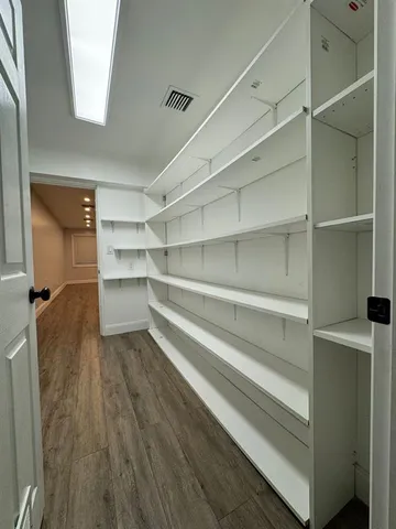 a view of walk in closet with empty racks
