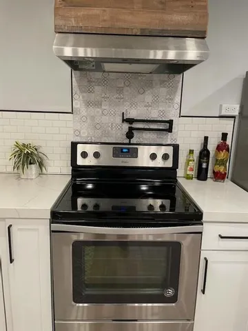 a stove top oven sitting inside of a kitchen