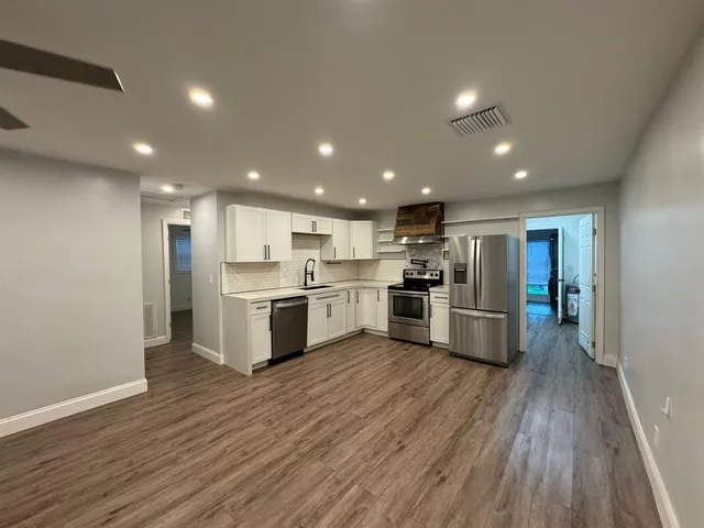 a kitchen with a refrigerator and a stove top oven