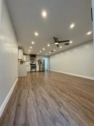 a view of empty room with wooden floor