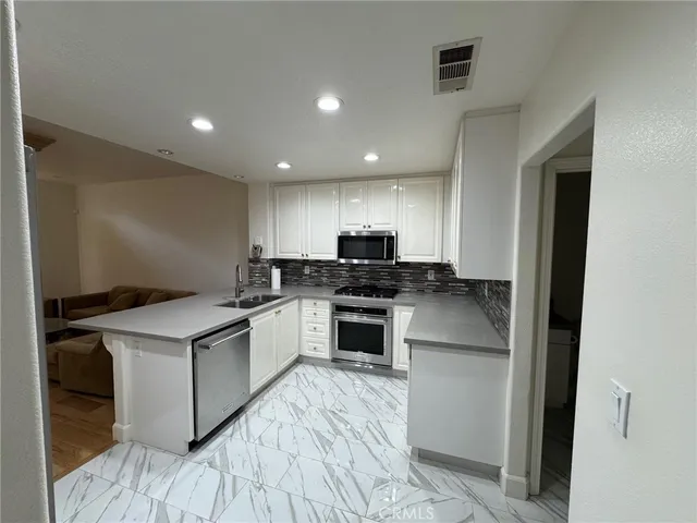 a kitchen with a stove top oven and cabinets