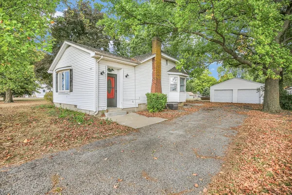 a view of a house with a yard and large tree