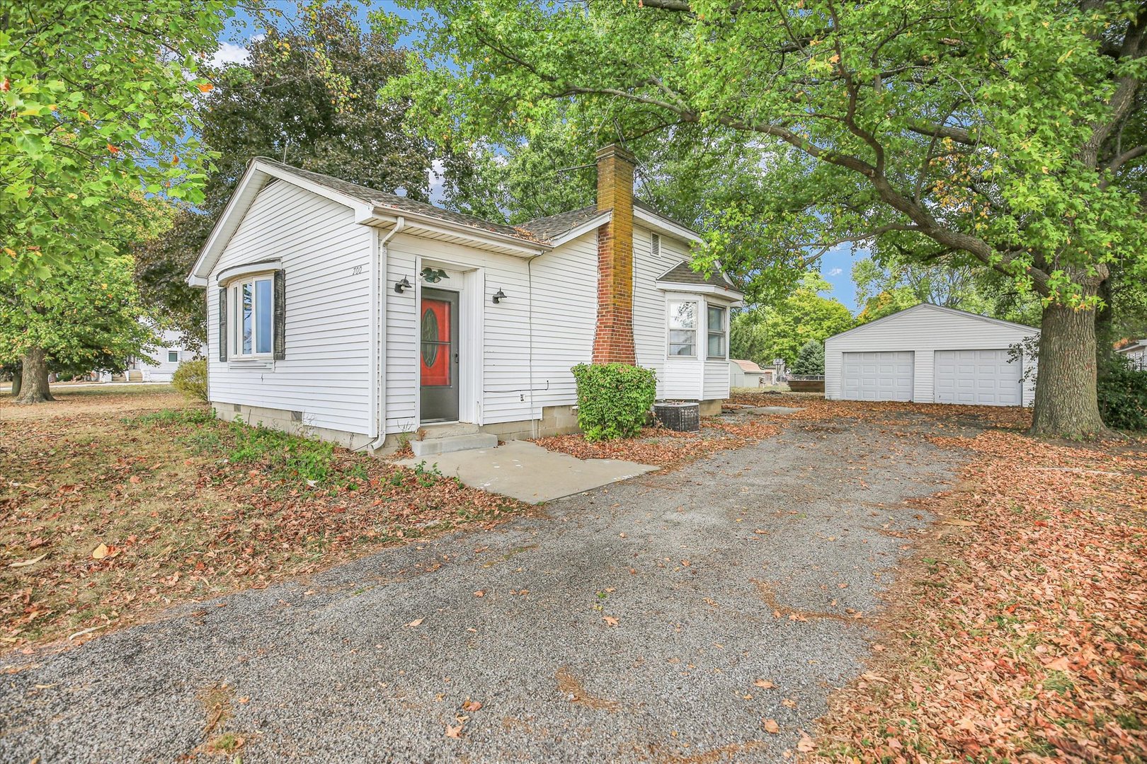 a view of a house with a yard and large tree