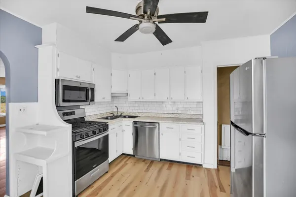 a kitchen with stainless steel appliances a stove sink and refrigerator