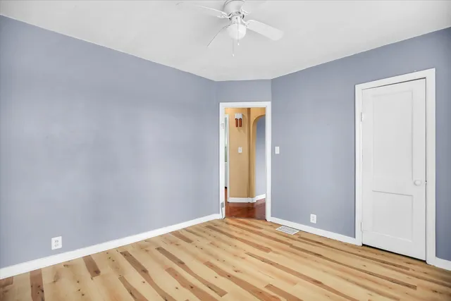 a view of room with wooden floor and fan
