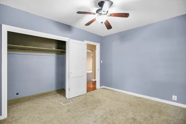 an empty room with closet and windows