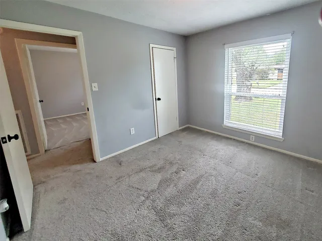 an empty room with windows and closet