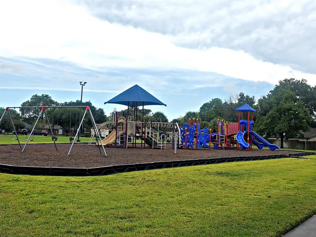 a view of outdoor space with playground and green space