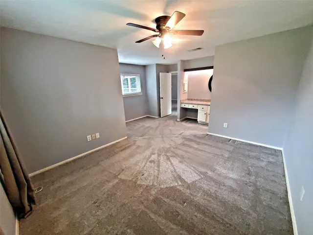 a view of a livingroom with a chandelier fan and fire place