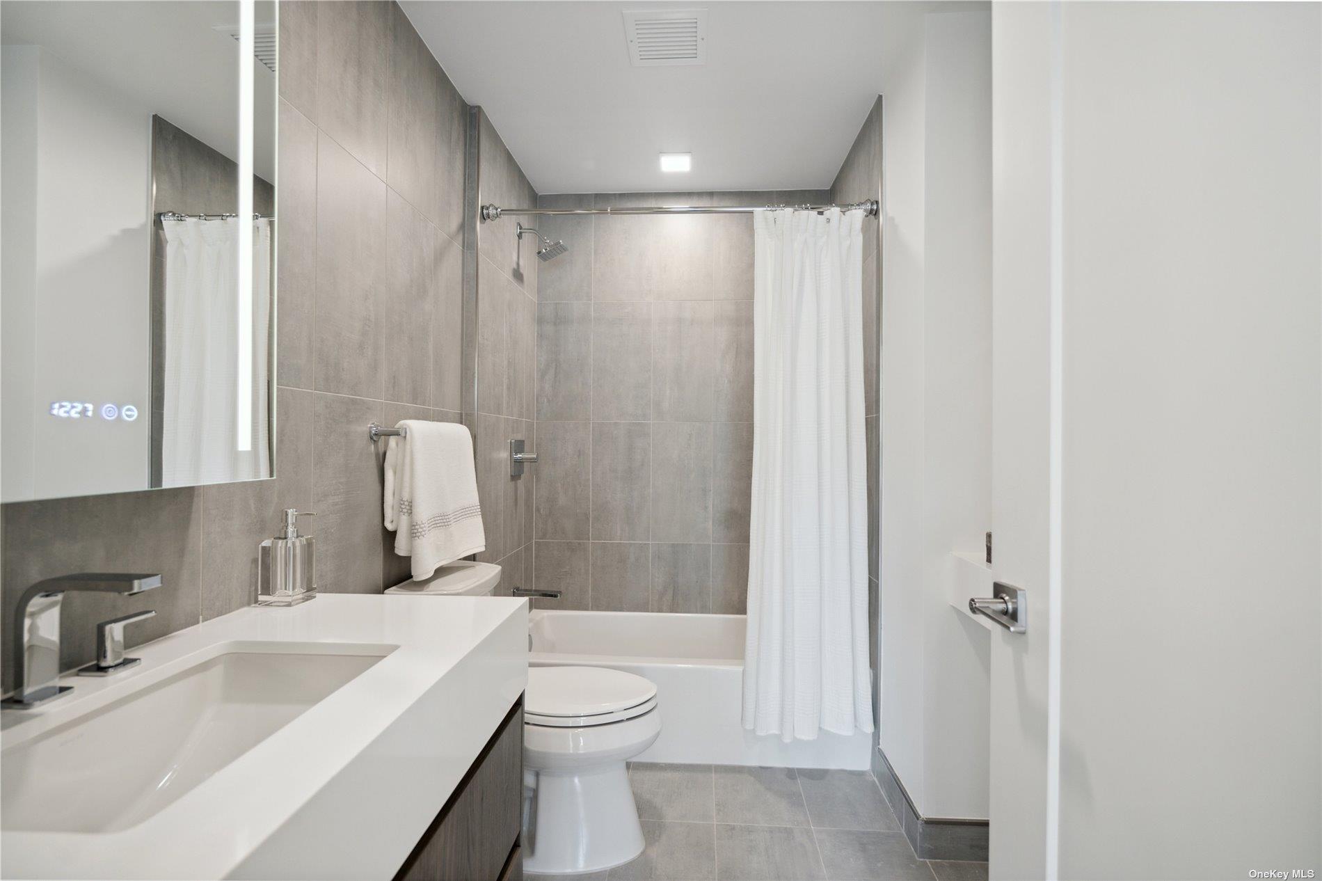 218 Middle Neck Road, Unit 203 Great Neck, NY 11021 - Photo 22 of 29 a bathroom with a sink toilet and shower