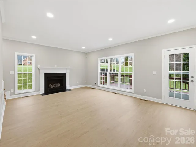 a view of an empty room with a fireplace and a window