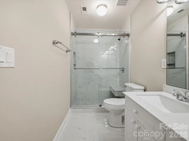 a bathroom with a granite countertop sink toilet and shower