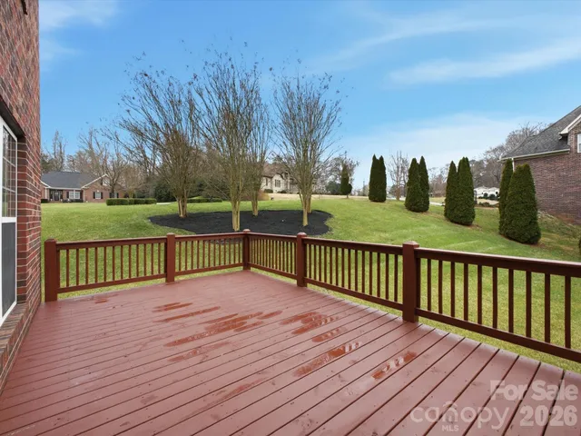 a view of a deck with wooden floor and fence with a large garden