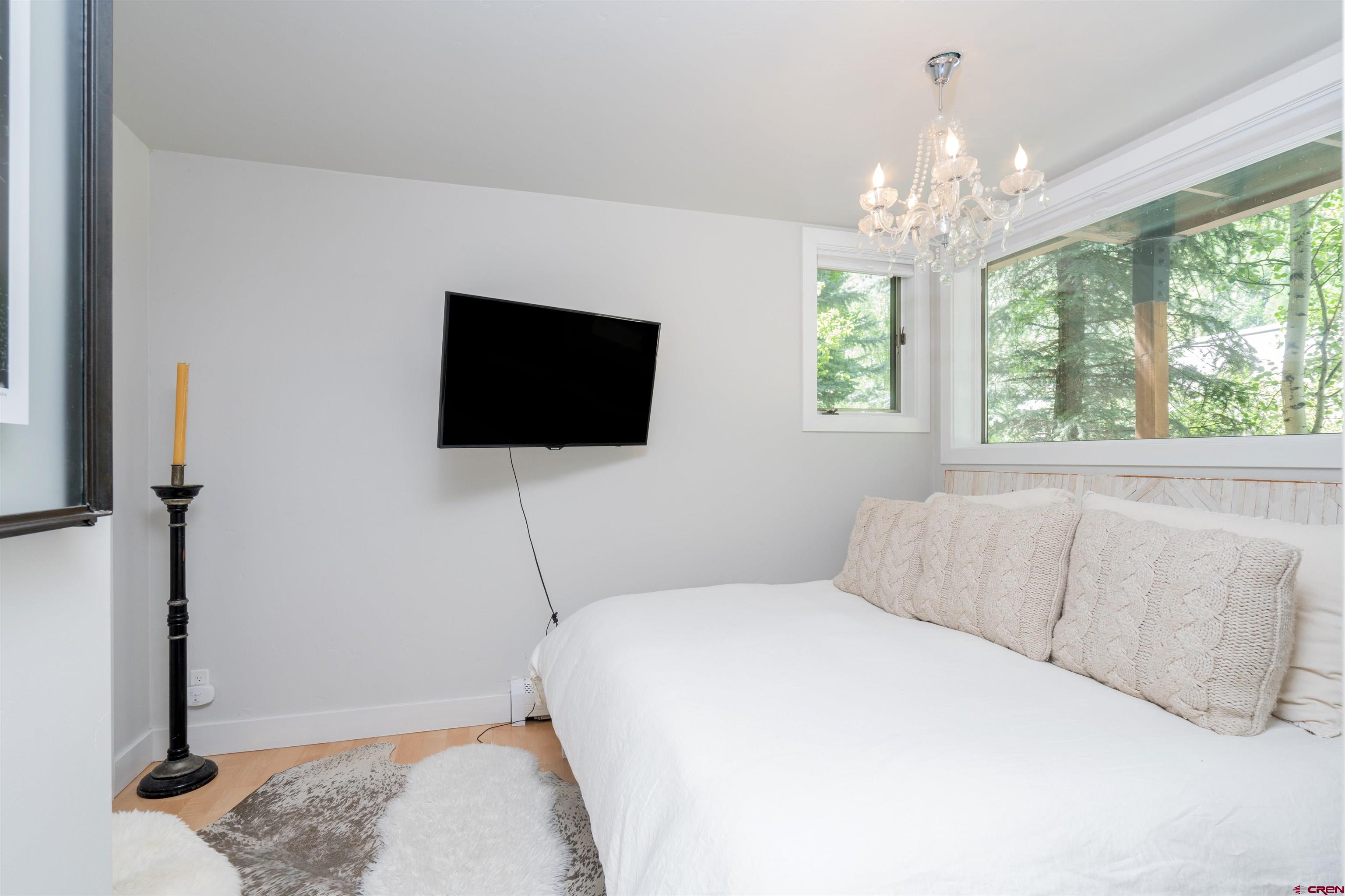 791 West Pacific Avenue, Unit 4H Telluride, CO 81435 - Photo 12 of 15 a bedroom with a bed and a flat screen tv