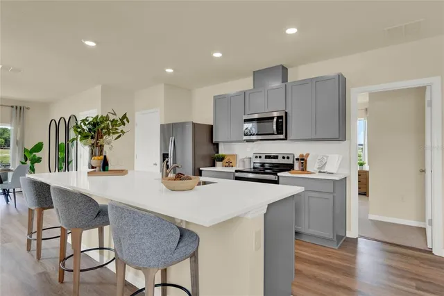 a kitchen with kitchen island appliances cabinets and wooden floor