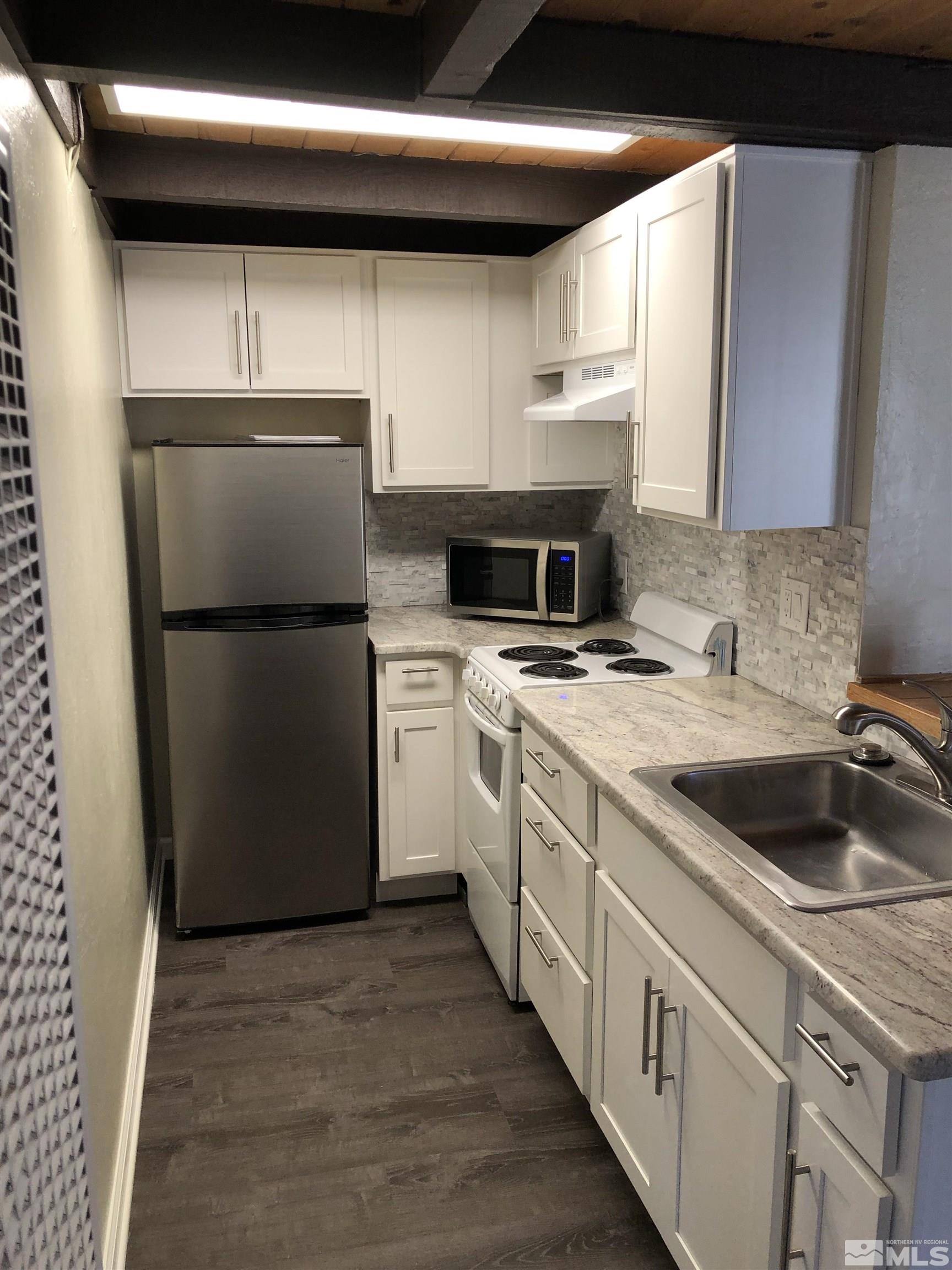 331 Tramway Drive, Unit 20 Stateline, NV 89449 - Photo 6 of 35 a kitchen with a sink a refrigerator and cabinets
