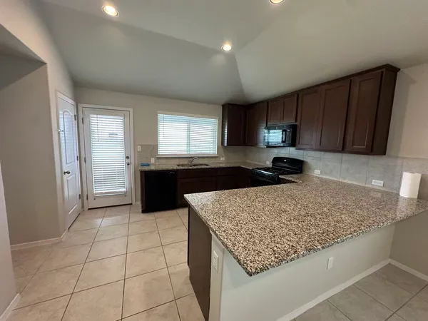 a kitchen with granite countertop sink and cabinets