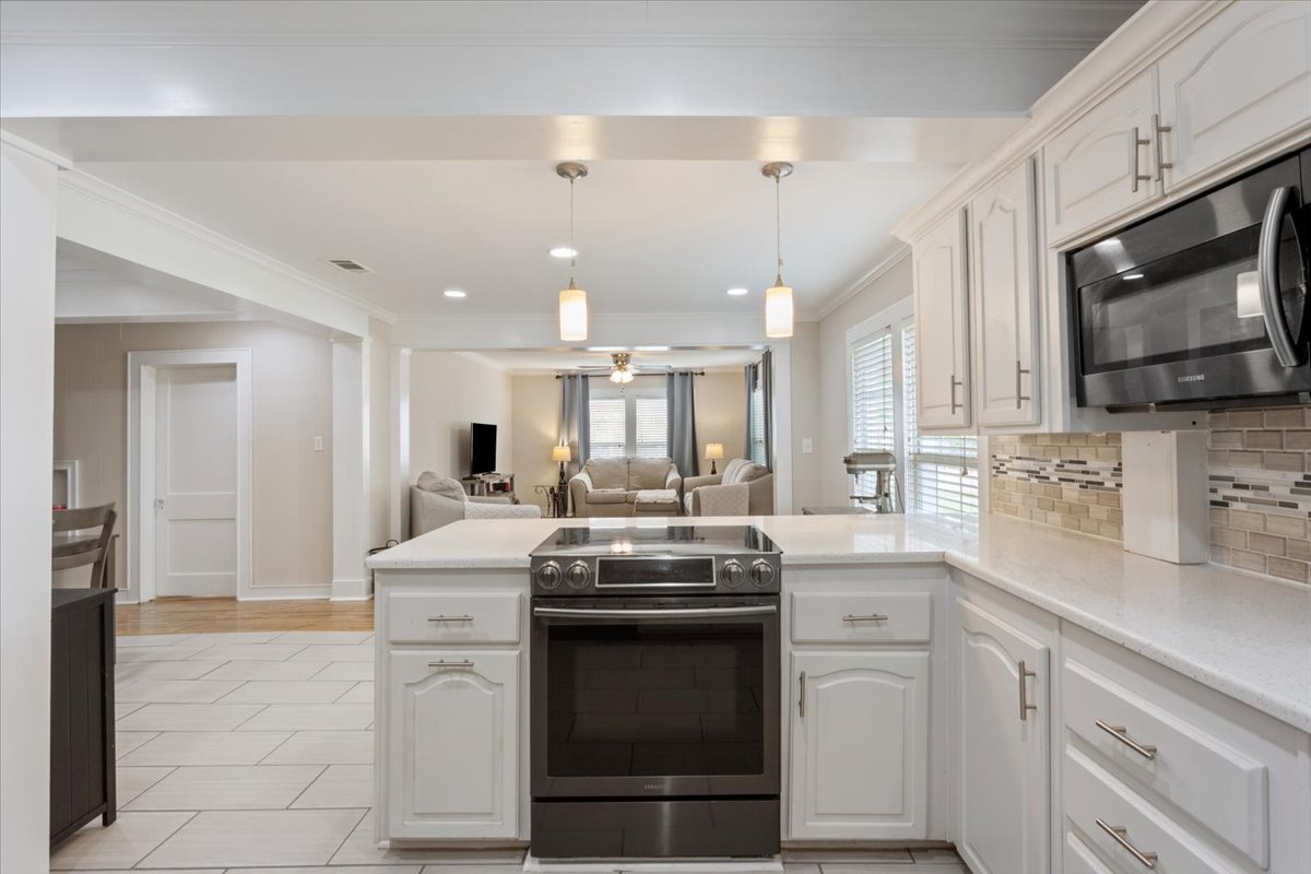 1607 North Harding Avenue Cameron, TX 76520 - Photo 15 of 37 An open-concept design connects the well-appointed kitchen to the comfortable living area.