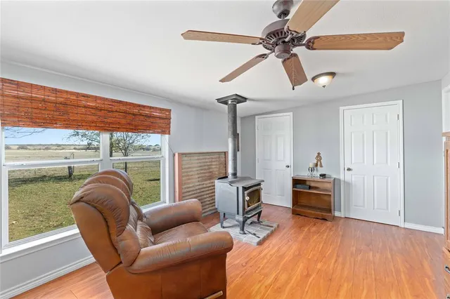 a living room with furniture floor to ceiling window and wooden floor