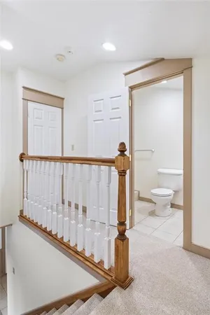 a view of a hallway with toilet and natural light