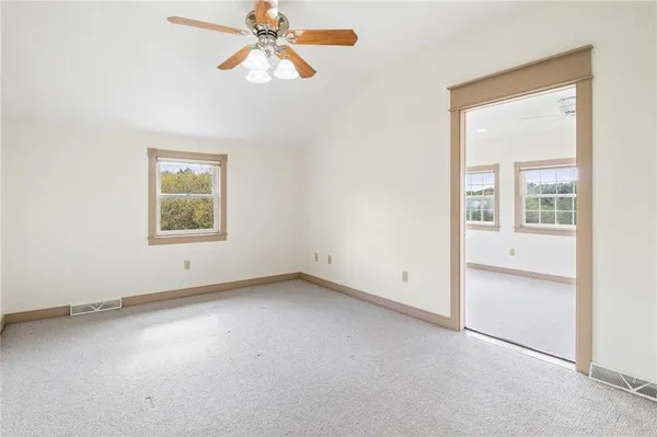 an empty room with a window and a ceiling fan