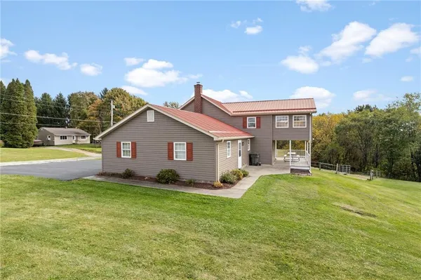 a view of a house with a yard and sitting area