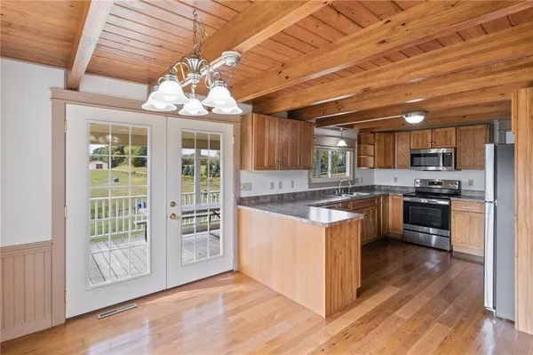 a kitchen with stainless steel appliances granite countertop a stove cabinets and wooden floor