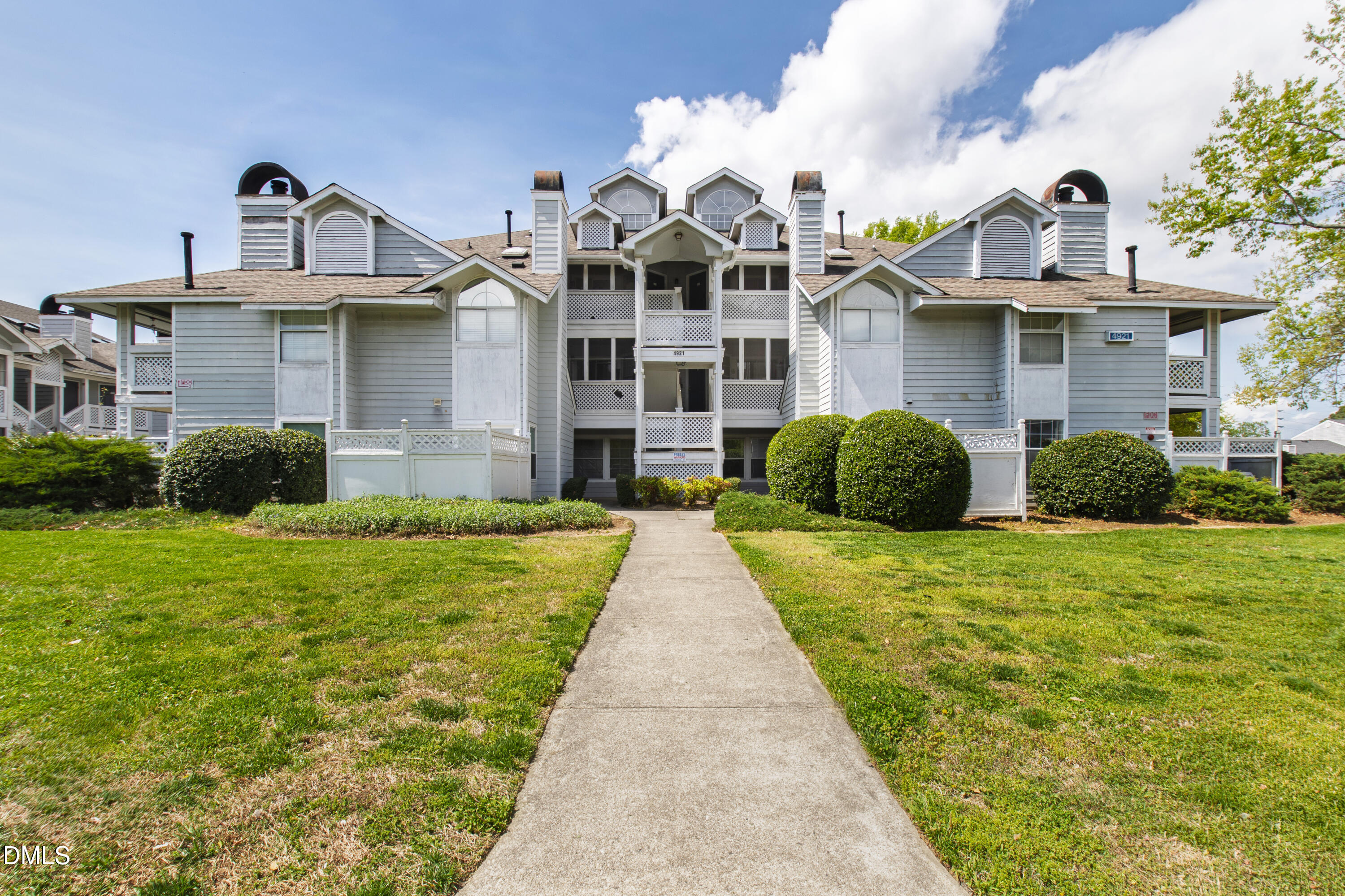 4921 Hollenden Drive, Unit 303 Raleigh, NC 27616 - Photo 1 of 33 a view of a white house with large windows and a small yard