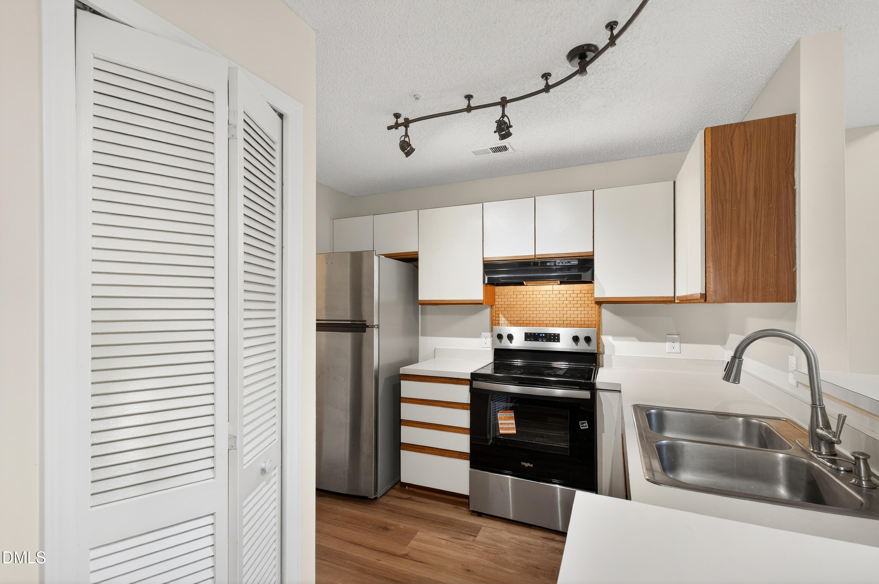 4921 Hollenden Drive, Unit 303 Raleigh, NC 27616 - Photo 11 of 33 a kitchen with a refrigerator and a sink