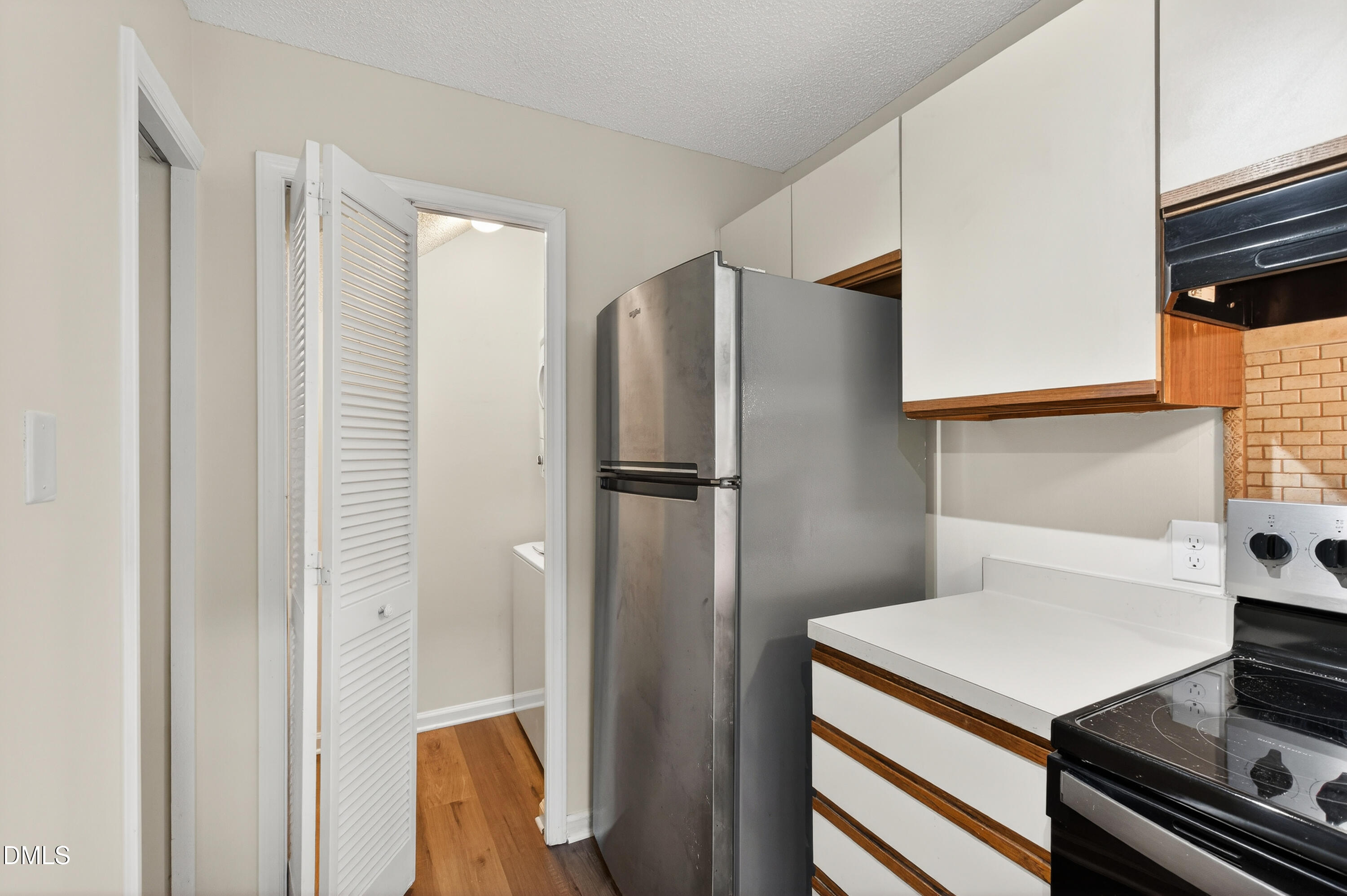 4921 Hollenden Drive, Unit 303 Raleigh, NC 27616 - Photo 13 of 33 a kitchen with stainless steel appliances a refrigerator and a stove top oven