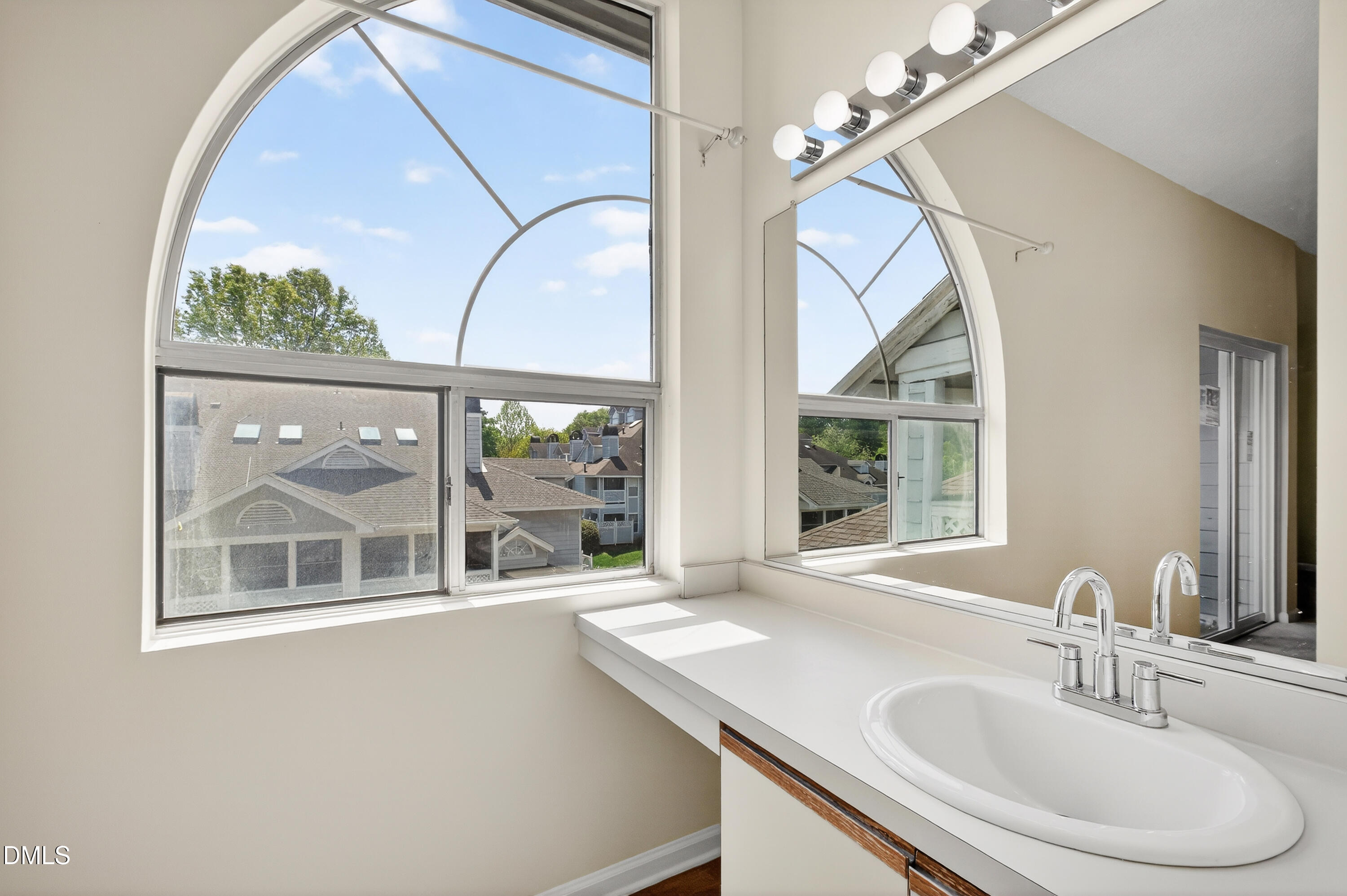 4921 Hollenden Drive, Unit 303 Raleigh, NC 27616 - Photo 20 of 33 a bathroom with a sink and a large mirror