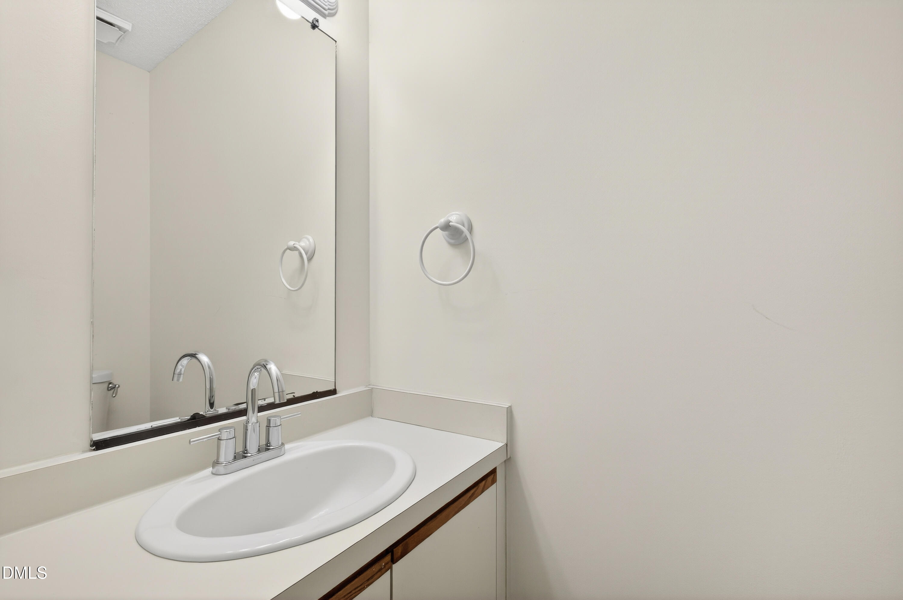 4921 Hollenden Drive, Unit 303 Raleigh, NC 27616 - Photo 26 of 33 a bathroom with a sink and a mirror