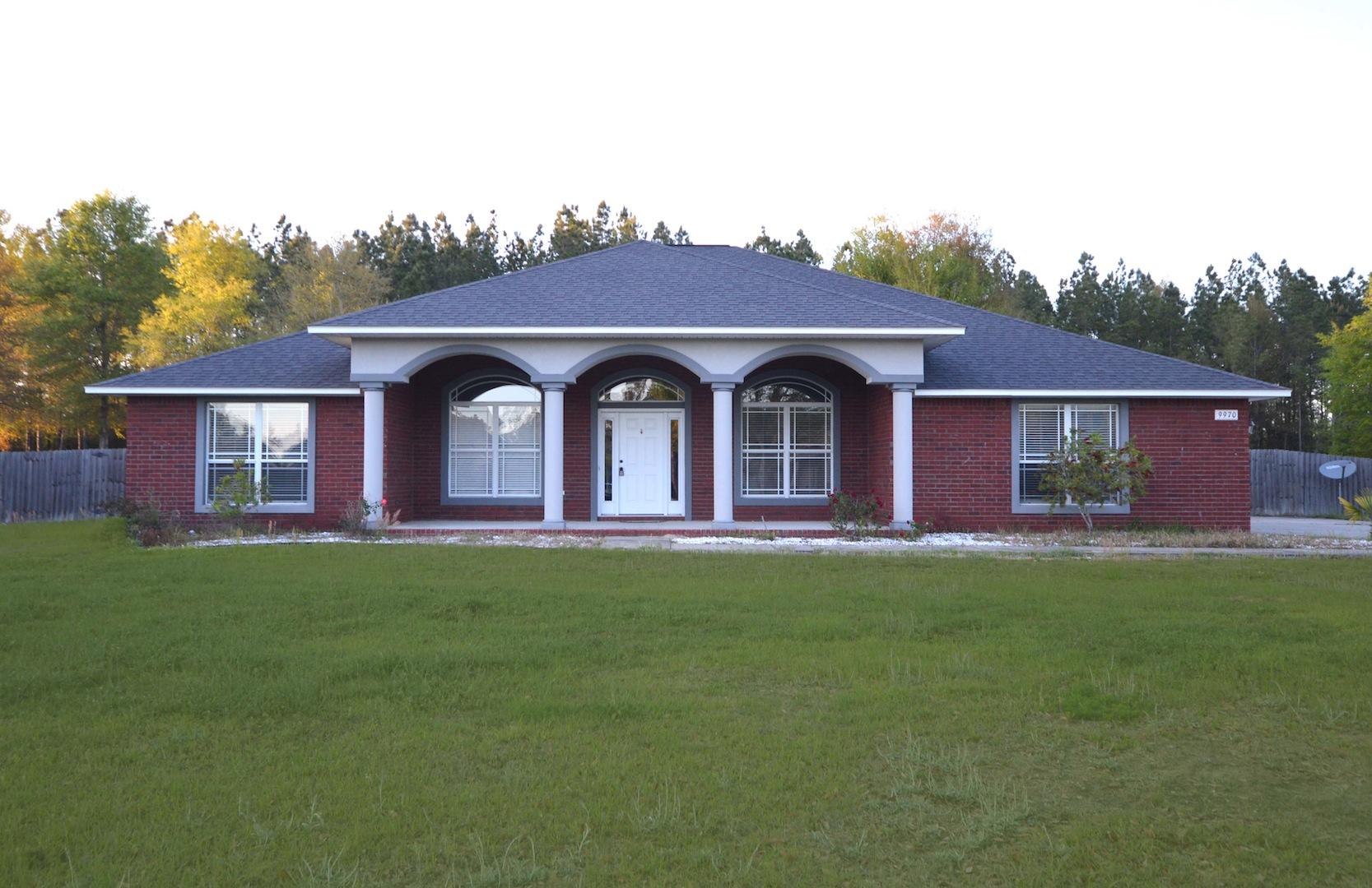 9970 Nichols Lake Road Milton, FL 32583 - Photo 1 of 48 a front view of a house with garden