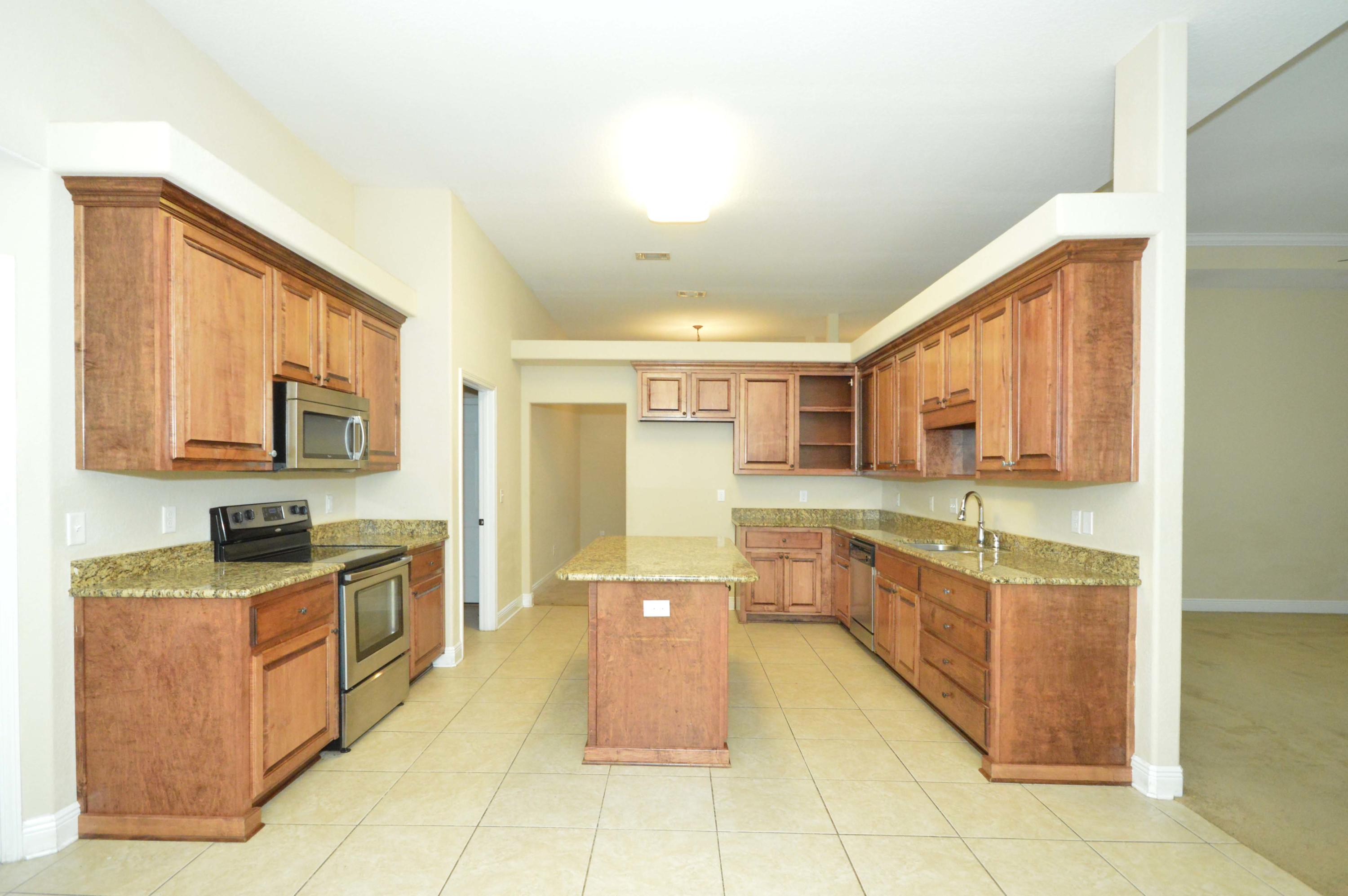 9970 Nichols Lake Road Milton, FL 32583 - Photo 18 of 48 a large kitchen with kitchen island granite countertop a large counter top and a stove
