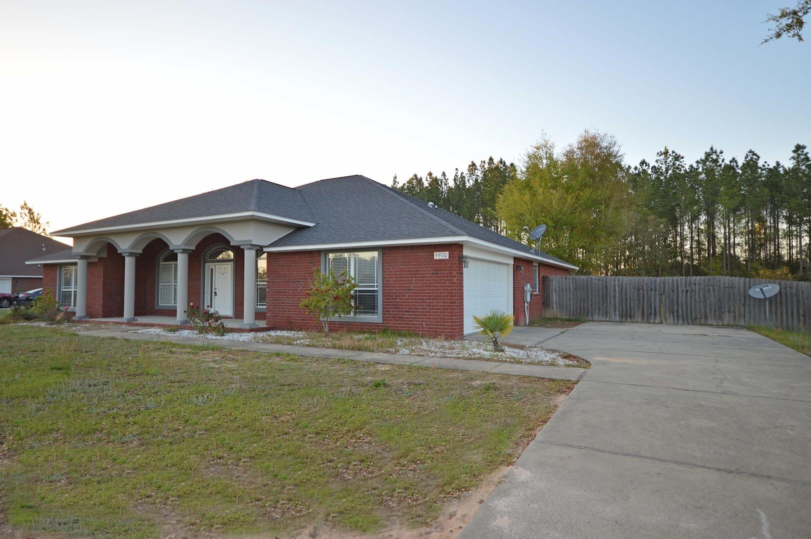 9970 Nichols Lake Road Milton, FL 32583 - Photo 2 of 48 a house view with a garden space