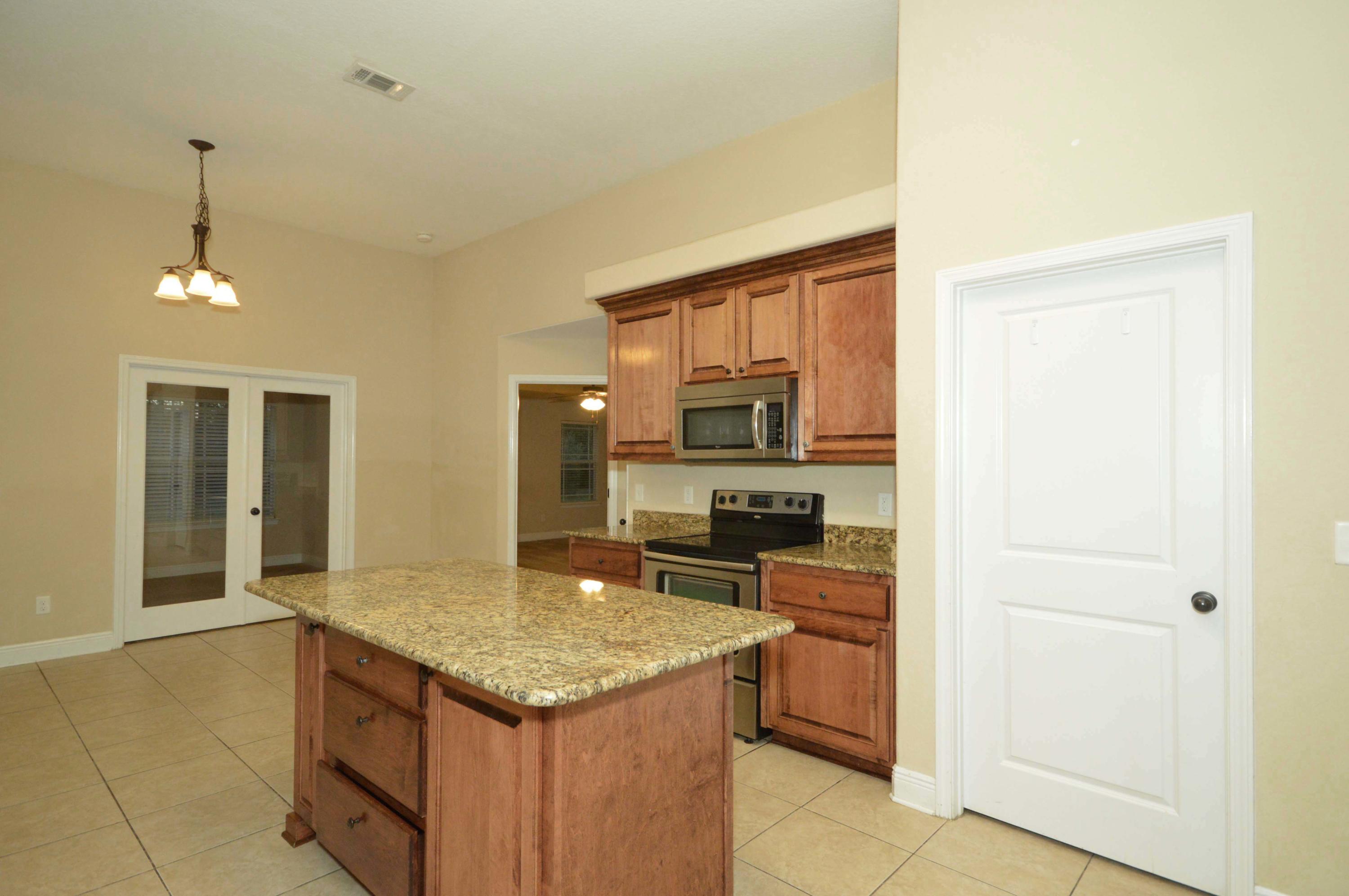 9970 Nichols Lake Road Milton, FL 32583 - Photo 23 of 48 a kitchen with a stove a refrigerator and a sink