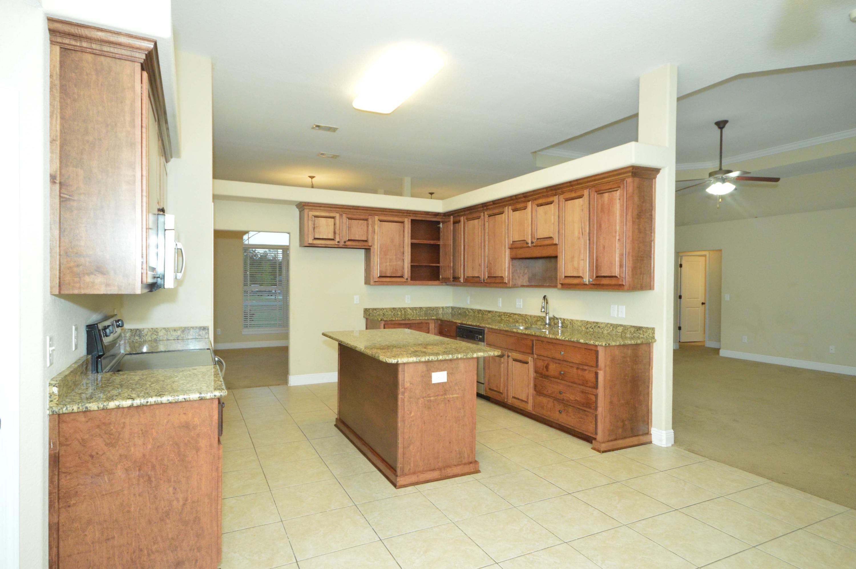9970 Nichols Lake Road Milton, FL 32583 - Photo 24 of 48 a large kitchen with stainless steel appliances granite countertop a sink and cabinets